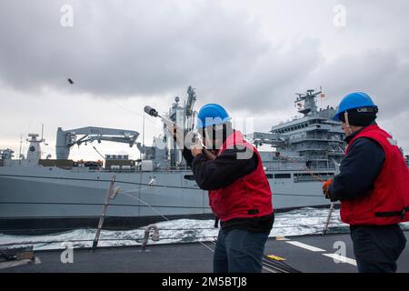 ATLANTIK (24. Februar 2022) – Gunner's Mate 2. Klasse Alfred Keen, Left, feuert eine Schusslinie auf das deutsche Hilfsschiff FGS Berlin (A1411), während Gunner's Mate 3. Klasse Joseph Ferro die Spule des Arleigh Burke-Klasse-Guided-Raketenzerstörers USS Donald Cook (DDG 75) hält Während der NATO-Übung Dynamic Guard 22-01, Februar 24. Donald Cook wird im europäischen Operationssaal eingesetzt und nimmt an einer Reihe von maritimen Aktivitäten zur Unterstützung der USA Teil Sechste Flotte und NATO-Alliierten. Stockfoto