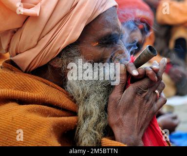 Ein Shaivite Sadhu raucht Chillum auf dem Mallick Ghat am Hooghly River in Kalkutta, Indien. Stockfoto