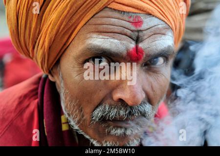 Ein Shaivite Sadhu raucht Chillum auf dem Mallick Ghat am Hooghly River in Kalkutta, Indien. Stockfoto