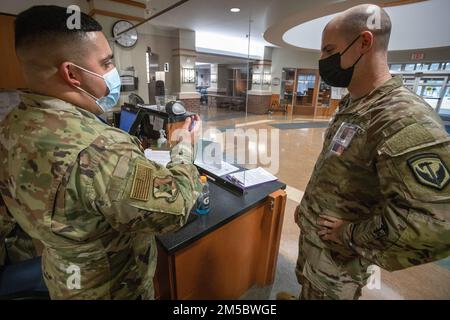 USA Army 1. LT. Jeffrey M. Silver, Right, Headquarters and Headquarters Company, 42. Regional Support Group, New Jersey Army National Guard, wird informiert von Staff Sgt. Pedro J. Benitez, Wartungsgeschwader, 177. Fighter Wing, New Jersey Air National Guard, im New Jersey Veterans Memorial Home in Vineland, New Jersey, 24. Februar 2022. Silver dient den Bewohnern des Hauses als verantwortlicher Vineland-Offizier. Mehr als 70 Soldaten der New Jersey National Guard und Airmen dienen als zertifizierte Pflegehelfer und in den Bereichen Lebensmittel, Infektionskontrolle, Informationstechnologie, Leben Stockfoto