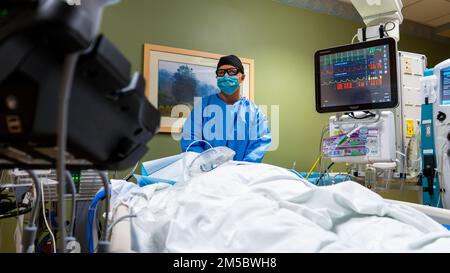 YUMA, Ariz - USA Air Force Capt. Michael Burnett, ein ärztlicher Assistent der 75. Operation Medical Readiness Squadron, Hill Air Force Base, untersucht die Arterien eines Patienten am Yuma Regional Medical Center in Yuma, Arizona, am 24. Februar 2022 mit Ultraschall. Die USA Flugzeuge werden eingesetzt, um die fortgesetzten Maßnahmen zur Bekämpfung von COVID-Infektionen des Verteidigungsministeriums zu unterstützen, um notleidenden Gemeinschaften zu helfen. USA Nördliches Kommando, durch die USA Army North ist nach wie vor entschlossen, das Verteidigungsministerium flexibel bei der COVID-Reaktion der gesamten Regierung zu unterstützen. Stockfoto