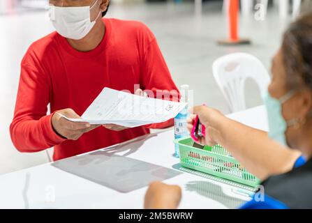 Offier überprüfe vor der Injektion des Impfstoffes die persönliche Krankengeschichte. Stockfoto