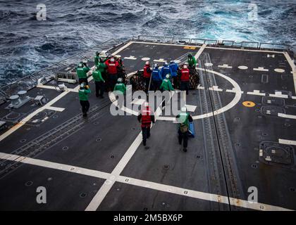 Matrosen an Bord des Zerstörers USS Delbert D. Black (DGG 119) brechen während einer vertikalen Nachschub mit dem Nachschuböler USNS John Lenthall (T-AO-189) Vorräte auf, während sie auf dem Weg zum Surface Warfare Advanced Tactical Training (SWATT) sind. Delbert D. Black ist Teil der Destroyer Squadron (DESRON) 26, die die Carrier Strike Group (CSG) 10 unterstützt. SWATT wird vom Naval Surface and Mine Warfighting Development Center (SMWDC) geleitet und soll die Kampffähigkeit, die Letalität und die Interoperabilität der teilnehmenden Einheiten verbessern. Stockfoto