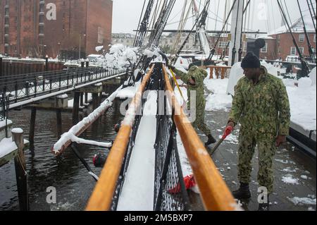 BOSTON (25. Februar 2021) Seemann Jordan Sharp, Left, aus Cincinnati, und Seaman Swafdar Ssekiziyivu aus Los Angeles, schaufeln Schnee an Bord der USS Constitution. Während des normalen Betriebs bieten die an Bord der USS Constitution stationierten aktiven Matrosen kostenlose Touren an und bieten jährlich mehr als 600.000 Menschen Besuchsmöglichkeiten an, da sie die Mission des Schiffes unterstützen, die Geschichte und das maritime Erbe der Marine zu fördern und das Bewusstsein für die Bedeutung einer nachhaltigen Marinepräsenz zu schärfen. Die USS Constitution wurde in der Schlacht nicht besiegt und zerstörte oder eroberte 33 Gegner. Das Schiff erhielt den Spitznamen Old IR Stockfoto