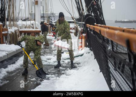 BOSTON (25. Februar 2021) Seemann Jordan Sharp, Left, aus Cincinnati, und Seaman Swafdar Ssekiziyivu aus Los Angeles, schaufeln Schnee an Bord der USS Constitution. Während des normalen Betriebs bieten die an Bord der USS Constitution stationierten aktiven Matrosen kostenlose Touren an und bieten jährlich mehr als 600.000 Menschen Besuchsmöglichkeiten an, da sie die Mission des Schiffes unterstützen, die Geschichte und das maritime Erbe der Marine zu fördern und das Bewusstsein für die Bedeutung einer nachhaltigen Marinepräsenz zu schärfen. Die USS Constitution wurde in der Schlacht nicht besiegt und zerstörte oder eroberte 33 Gegner. Das Schiff erhielt den Spitznamen Old IR Stockfoto