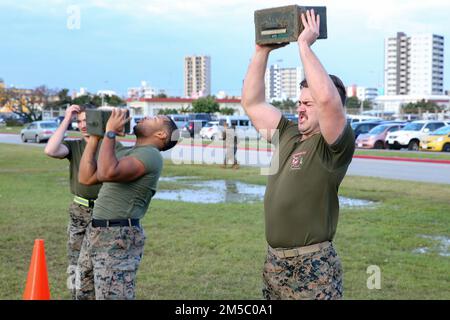 USA Navy Petty Officer zweiter Klasse David Wright, Left, und Hospitalman Liam Morgan, Sanitäter mit 3. Medizinischem Bataillon, 3. Marine Logistics Group, führen Munitionsbecher-Lifts während des Corpsman Cup in Camp Foster, Okinawa, Japan, am 25. Februar 2022 durch. Der Corpsman Cup ist eine jährlich stattfindende Herausforderung, an der Marines und Matrosen teilnehmen, um Kameradschaft aufzubauen und lebensrettende Fähigkeiten zu üben. Stockfoto
