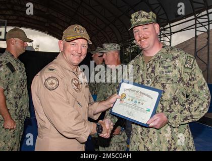 USA Navy Air Traffic Controller 1. Class Michael Doherty, ein Seemann von Media, Pa, wird während einer Zeremonie im Lager am 25. Februar von Captain David Faehnle, dem befehlshabenden Offizier des Lagers Lemonnier, Dschibuti, ein Dankeszeugnis überreicht. Stockfoto