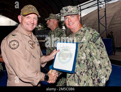 USA Navy Construction Electrician 2. Class Jeffrey Baird, ein Segler aus Las Vegas, wird während einer Zeremonie im Lager am 25. Februar von Captain David Faehnle, dem kommandierenden Offizier des Lagers Lemonnier, Dschibuti, ein Empfehlungsschreiben überreicht. Stockfoto