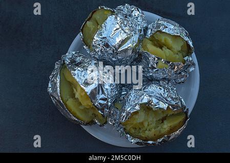 In Aluminiumfolie verpackte Jacketkartoffeln, Bayern, Deutschland Stockfoto