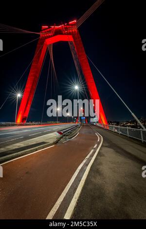 Eine vertikale Aufnahme der Willemsbrug- oder Williams-Brücke in Rotterdam, Niederlande bei Nacht Stockfoto