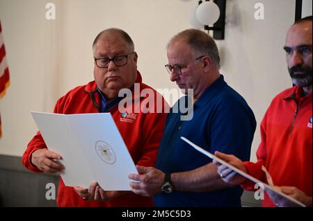 Bill Burket, Direktor des Virginia Port Authority Maritime Incident Response Team, überreicht Mark Clemens am 28. Februar 2022 auf dem Hampton Roads Search and Rescue Forum in Hampton, Virginia, den Coast Guard Public Service Commendation Award. Clemens ist eines von drei Besatzungsmitgliedern des Wochenend-Kriegers, der im Februar 2021 zwei Seeleute aus ihrem brennenden Schiff rettete. Stockfoto