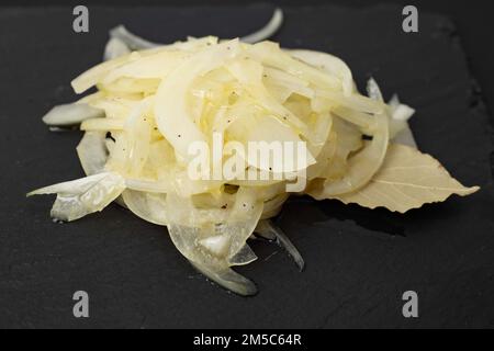 Marinierte weiße Zwiebel auf schwarzem Stein, Nahaufnahme mit weichem Fokus Stockfoto