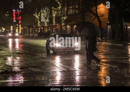 Seattle, USA. 27. Dezember 2022. Hochwind und Landfluten beobachten den Puget Sound, während die Menschen früh am Abend auf der 4. Avenue durch den Sturm navigieren. James Anderson/Alamy Live News Stockfoto