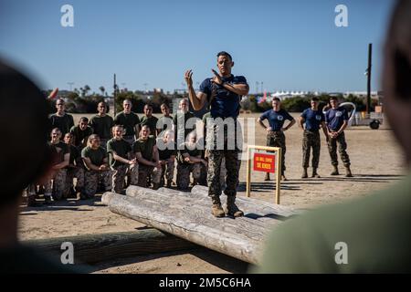 USA Marinekorps Staff Sgt. Jonathan Fuentes, Senior Drill Instructor bei Mike Company, 3. Recruit Training Battalion, unterrichtet Rekruten über die richtigen Techniken für Holzbohrer im Marine Corps Recruit Depot San Diego, 28. Februar 2022. Die Rekruten haben vor der Durchführung der Übungen eine Demonstration der richtigen Hebetechniken beobachtet. Stockfoto