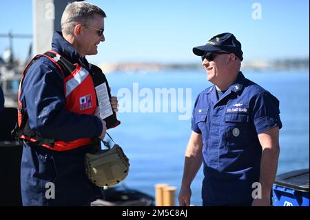 Stellvertretender Befehlshaber der Pazifikregion Peter Gautier und Master Chief Greg Via, Kommandomeister der USA Küstenwache San Diego, Vortrag auf dem Pier von Sektor San Diego während der Admiralreise durch den Stützpunkt am 28. Februar 2022. Der Zweck des Besuchs ist es, Partnerschaften hervorzuheben und sicherzustellen, dass die Einheiten der Küstenwache in San Diego einen soliden Plan für die Zukunft haben. Stockfoto