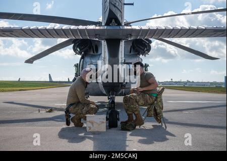 Senior Airman Joshua May, Left, und Airman 1. Class Ricky Vega, beide 33. Helicopter Maintenance Unit Crew Chiefs, führen Wartungsarbeiten an einem HH-60G Pave Hawk während einer 18. Wing Bereitschaftsübung am Kadena Air Base, Japan, am 1. März 2022 durch. Während der Routineübung führt Kadena Airmen Schulungen durch, um die technischen Fähigkeiten zu verbessern und die Einsatzbereitschaft der Basis zu verbessern. Stockfoto