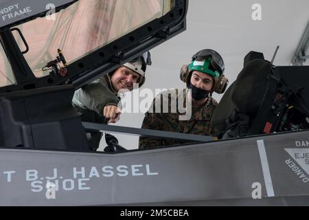 USA Oberst Derek Brannon, Befehlshaber der Marine Aircraft Group 12, spricht mit CPL. Dawson Quistorff, Spezialist für Bestandsverwaltung, an der Marine Corps Air Station Iwakuni, Japan, 1. März 2022. USA Generalleutnant Ricky N. Rupp, Befehlshaber der US-Streitkräfte Japan, besuchte Staffeln bei MCAS Iwakuni, um das Engagement der Flugstation für die Allianz zwischen den USA und Japan und den Stand der militärischen Bereitschaft besser zu verstehen. MCAS Iwakuni ist ein fortschrittlicher Marinestützpunkt, der Positionsvorteile bietet, strategische Allianzen stärkt und Flottenoperationen und Marinekampagnen unterstützt. Stockfoto