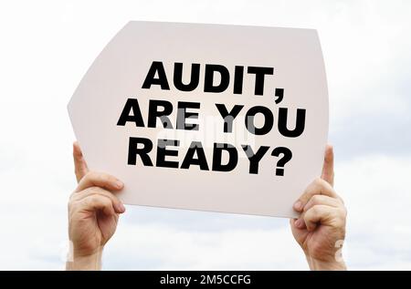 Geschäftskonzept. Vor dem Hintergrund des Himmels in den Händen eines Mannes ist ein Zeichen mit der Inschrift "Audit, bist du bereit" Stockfoto