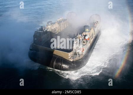 PAZIFIK (1. März 2022) Ein Landungsschiff mit Luftkissen, das an der Assault Craft Unit (ACU) 5 befestigt ist, führt Amphibienoperationen mit dem Amphibienschiff USS Essex (LHD 2) der Wasp-Klasse vom 1. März 2022 durch. Matrosen und Marines der Essex Amphibious Ready Group (ARG) und der 11. Marine Expeditionary Unit (MEU) führen derzeit Routineeinsätze in der US-3.-Flotte durch. Stockfoto