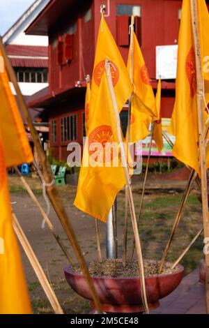 Nahaufnahme der gelben buddhistischen Flaggen (die Dharmacakra-Flagge) vor dem Phan Tao-Tempel in Chiang Mai, Thailand. Stockfoto