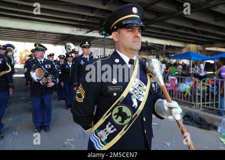 Sgt. 1. Klasse Luigi Baccala, mit der 313. Armeegruppe aus Huntsville, Alabama, bereitet sich darauf vor, der Band während der Rex Parade am 1. März 2022 in New Orleans, Louisiana, die Richtung zu geben. Die Rex-Parade oder die Rex-Prozession war der Höhepunkt des Mardi-Gras-Tages, seit die Rex-Organisation gegründet wurde und 1872 zum ersten Mal vorgeführt wurde. Die an dieser Veranstaltung teilnehmenden Bands zeigen nicht nur das Talent der Soldaten, sondern können auch als Rekrutierungs-Tool verwendet werden und Beziehungen zur lokalen Gemeinschaft aufbauen. Stockfoto