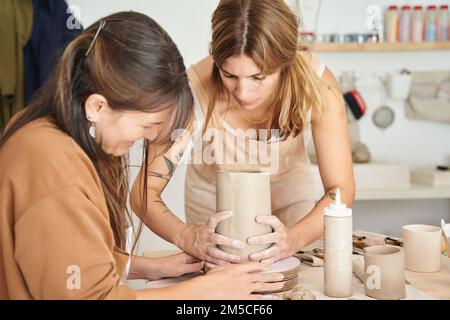 Zwei Frauen, die mit Ton in einer Töpferwerkstatt arbeiten. Handwerk, Kunst und Hobbys. Stockfoto