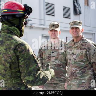 Kanadische Streitkräfte, LT. Oberst N.J Watts, der kommandierende Offizier des 15. Field Artillery Regiment aus Vancouver, BC, beschrieb U.S. Armeebrig. General David Pritchett, Leiter des gemeinsamen Stabs der Wyoming Army National Guard, und Oberstleutnant Stephen Koontz, Alaska Army National Guard, über die Such- und Extraktionskapazitäten Kanadas während der Übung Arctic Eagle-Patriot 22 im Anchorage Fire Training Center in Anchorage, Alaska, 1. März 22. Die gemeinsame Übung Arctic Eagle-Patriot 22 erhöht die Fähigkeit der Nationalgarde, in rauen, extrem kalten Witterungsbedingungen in Alaska und t zu operieren Stockfoto