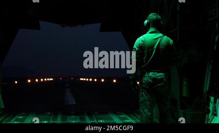 Der Ladermeister eines MC-130J Commando II-Mehrmission-Kampfflugzeugs, das dem 1. Special Operations Squadron, dem 353. Special Operations Wing, Beobachtet, wie die Flugzeuge nachts auf einem Flugplatz in der Provinz Lopburi des Königreichs Thailand im Rahmen eines Evakuierungstrainingszenarios für Opfer während der Übung Cobra Gold 2022 am 1. März 2022 taxen. CG 22 ist die 41.. Auflage der internationalen Trainingsübung, die die Bereitschaft unterstützt und die Koordinierung bei zivilem Handeln, humanitärer Hilfe und Katastrophenhilfe betont. Vom 22. Februar bis zum 4. März 2022 ist diese jährliche EV Stockfoto