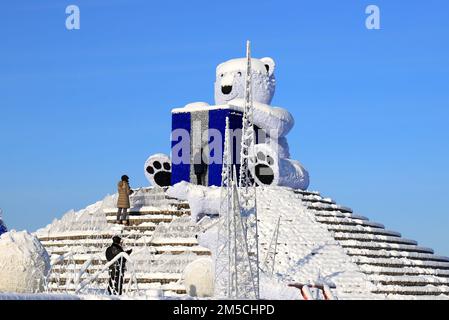 Großer Eisbär steht im Winter auf der Straße der Stadt, festliches Spielzeug. Die Leute gehen unter Weihnachtsdekorationen und Installationen. Dnipro, Ukraine 2022-01-02 Stockfoto