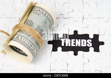 Geschäftskonzept. Dollars liegen auf weißen Rätseln, auf einer schwarzen Oberfläche ist eine Inschrift - Trends Stockfoto