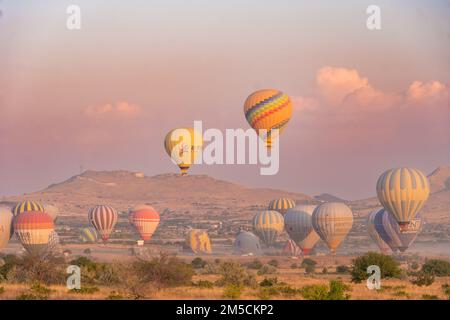 Kappadokien, Türkei-September 20 2022: Es gibt eine Menge Ballons am Himmel, einige Ballons landen. Heißluftballonflüge in Kappadokien Stockfoto