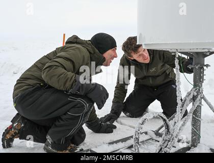 220302-N-JO245-1050 PRUDHOE BAY, Alaska (2. März 2022) – Bruce Billian (links) ist leitender Wissenschaftler, und Tyler Brant, ein Ingenieur, der dem Naval Information Warfare Center Atlantic zugewiesen ist, inspiziert kommerzielle Satellitenkommunikationsgeräte in Prudhoe Bay, Alaska. Billian und Brant testeten das Fanggerät, bei dem in der extremen Kälte im Norden Alaskas verbreitete Satellitenkonstellationen mit niedriger Erdumlaufbahn zum Einsatz kommen, bevor sie es in den USA nach Ice Camp Queenfish transportierten Eisübung der Marine (ICEX) 2022. Ice Camp Queenfish ist ein Lager, das auf einer Eisscholle 160 Seemeilen vor der Küste Alaskas in der A erbaut wurde Stockfoto