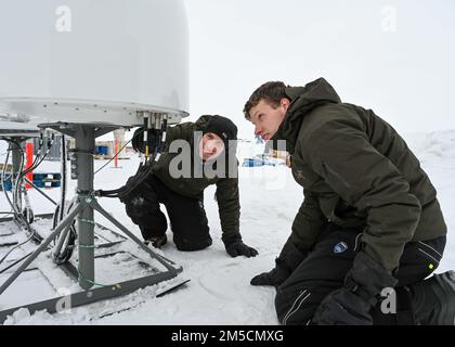 220302-N-JO245-1064 PRUDHOE BAY, Alaska (2. März 2022) – Bruce Billian (links) ist leitender Wissenschaftler, und Tyler Brant, ein Ingenieur, der dem Naval Information Warfare Center Atlantic zugewiesen ist, inspiziert kommerzielle Satellitenkommunikationsgeräte in Prudhoe Bay, Alaska. Billian und Brant testeten das Fanggerät, bei dem in der extremen Kälte im Norden Alaskas verbreitete Satellitenkonstellationen mit niedriger Erdumlaufbahn zum Einsatz kommen, bevor sie es in den USA nach Ice Camp Queenfish transportierten Eisübung der Marine (ICEX) 2022. Ice Camp Queenfish ist ein Lager, das auf einer Eisscholle 160 Seemeilen vor der Küste Alaskas in der A erbaut wurde Stockfoto