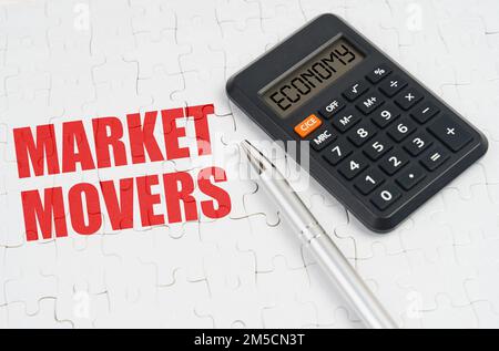 Geschäftskonzept. Auf den Rätseln liegen ein Taschenrechner und ein Stift neben der Inschrift Market Movers Stockfoto