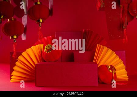Chinesischer Neujahrshintergrund, Podiumständer mit festlichen Chinislaternen, Papierbrötchen und Postern mit traditionellen Silvesterstreifen für Stockfoto