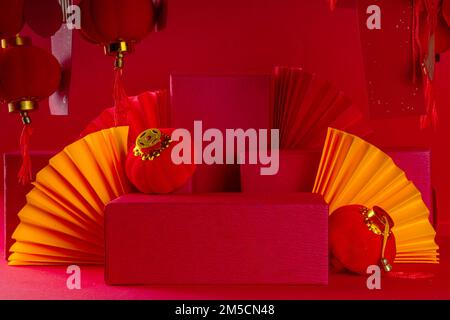Chinesischer Neujahrshintergrund, Podiumpräsentation mit festlichen chinesischen Laternen, Papierfächern und Postern mit traditionellen Silvesterstreifen für Stockfoto