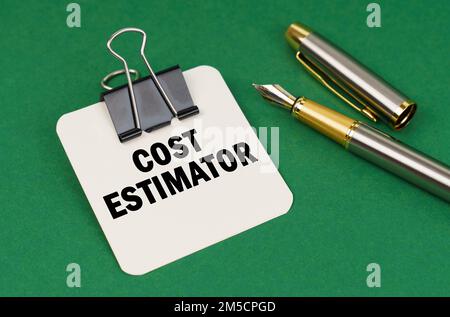 Geschäfts- und Branchenkonzept. Auf einer grünen Oberfläche, einem Stift und einem Blatt Papier mit der Aufschrift - Kostenschätzung Stockfoto