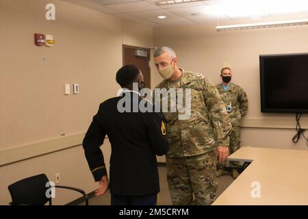 Kommandoleiter Major Adam Nash, einberufener Anführer der 4. Infanteriedivision und Fort Carson, schüttelt die Hand von Staff Sgt. Savon Tyree Hollimon, einem Kavallerie-Scout mit 1. Bataillon, 68. Rüstungsregime, 3. Kampfteam der Brigade, 4. Inf. Div., nach dem Vorstand des Sergeant Audie Murphy Club (SAMC) im 4. Div Hauptquartier in Fort Carson, Colorado, 2. März 2022. Die Einführung und Mitgliedschaft in der SAMC ist eine Belohnung für nicht kommissionierte Offiziere, deren Führungsleistungen besondere Anerkennung verdienen. Stockfoto