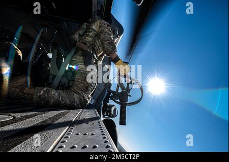 USA Air Force Staff Sergeant Brody Gates, 41. Rettungsschwadron Special Missions Aviator, bereitet einen Aufzug während des Rettungstrainings für den Exercise Ready Tiger 22-01 in der Nähe des Moody Air Force Base, Georgia, 2. März 2022 vor. Die Tore übten, die Hebebühne mit einem Objekt auf dem Boden auszurichten, während die Piloten sich in Position bewegten. Die 41. RQS übten während des Fluges Tanken, Such- und Rettungsmanöver sowie Kampfmanöver. Ready Tiger ist eine Lead-Wing-Übung, bei der die Fähigkeit von Moody getestet wird, Luftstützschwadronen einzusetzen, um in umkämpften Umgebungen Luftstrom zu erzeugen und Kommando und Kontrolle aufrechtzuerhalten. Stockfoto