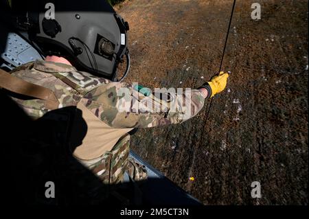 USA Air Force Staff Sergeant Brody Gates, 41. Rettungsschwadron Special Missions Aviator, senkt eine Hebebühne während des Rettungstrainings für Exercise Ready Tiger 22-01 nahe Moody Air Force Base, Georgia, 2. März 2022. Die Entnahme von Hebezeugen ist eine gängige Methode, die der 41. RQS zur Rettung von Überlebenden in verschiedenen Umgebungen einsetzt. Die 41. RQS übten während des Fluges Tanken, Such- und Rettungsmanöver sowie Kampfmanöver. Ready Tiger ist eine Lead-Wing-Übung, bei der die Fähigkeit von Moody getestet wird, Luftstützschwadronen einzusetzen, um in umkämpften Umgebungen Luftstrom zu erzeugen und Kommando und Kontrolle aufrechtzuerhalten. Stockfoto