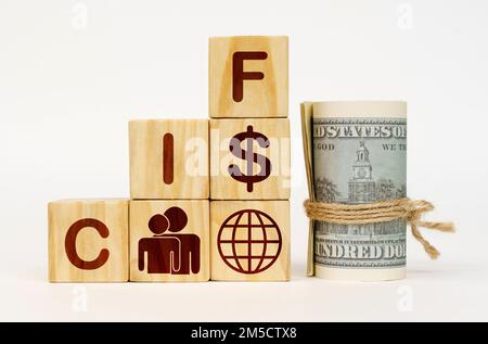 Geschäftskonzept. Auf einer weißen Oberfläche, Dollars und Würfel mit Bildern und der Inschrift - CIF Stockfoto
