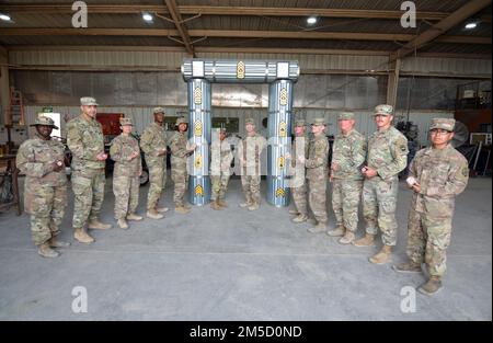 Kommandosgt. Major Michael J. Perry III, hochrangiger Berater, 1. Kommandobereich Theater Sustainment, und Kommandosgt. Major Phelicea M. REDD, hochrangiger Rekrutierer, 1. Einsatzkommando des TSC, mit Soldaten posieren, die dem 389. Bataillon zur Unterstützung des Kampfes gegen Nachhaltigkeit in Camp Buehring, Kuwait, 2. März 2022 zugeteilt wurden. Die Soldaten aus der Abteilung Allied Trades der 1063. Support Maintenance Company bauten einen nicht kommissionierten Offiziersbogen zur Vorbereitung einer NCO-Einführungszeremonie, die später im Jahr geplant ist. Stockfoto