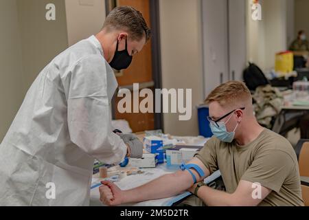 Staff Sgt. Jordan Dean, ein Leiter der Behandlungseinheit, zugewiesen zum 4. Geschwader, 10. Kavallerie-Regiment, 3. Panzerbrigade-Kampfteam, 4. Infanterie-Division, bereitet sich auf die Blutspende von 1. LT. Austin R. Odium vor, einem Quartiermeister-Offizier, der 4. Quadratmeter, 10. Kavitäten zugewiesen ist. Reg., 3. ABCT, 4. Inf. Div., 3. März 2022, während einer Blutspendeaktion des Armed Service Blood Program (ASBP) mit Sitz in Fort Bliss, Texas, durchgeführt in Fort Carson, Colorado. Dean koordinierte die Blutspende mit der ASBP. Stockfoto