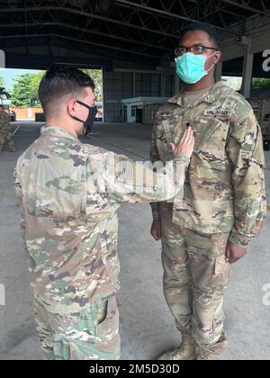 Army SPC. Treavon Myers (rechts), Mitglied des Hauptquartiers, Headquarters Company ‚Talons,‘ 2. Bataillon, 25. Luftfahrtregiment, 25. Kampfluftfahrtbrigade, 25. Infanterieabteilung, wird während der Übung Cobra Gold 2022 in der Provinz Lopburi des Königreichs Thailand am 3. März 2022 befördert. CG 22 ist die 41. Wiederholung der internationalen Ausbildungsübung, die die Bereitschaft unterstützt und die Koordinierung in den Bereichen Bürgeraktion, humanitäre Hilfe und Katastrophenhilfe betont. Vom 22. Februar bis zum 4. März 2022 findet diese jährliche Veranstaltung an verschiedenen Orten im ganzen Königreich statt Stockfoto