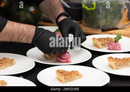 Der Chef serviert ein Stück Apfelkuchen und Sorbet Stockfoto