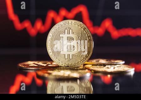 Globale Rezession. Finanzkrise. Bild eines goldenen Bitcoins, das sich zwischen Stapeln anderer Kryptomünzen erhebt, auf digitalem Hintergrund einer Karte mit einer dicken roten Linie, die den Zusammenbruch des Kryptohandelsmarktes darstellt Stockfoto