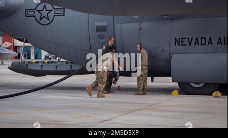 Flieger der Nevada und der Hawaii Air National Guard entladen Treibstoff aus einem Nevada C-130 Hercules-Flugzeug an der Marine Corps Air Station Kaneohe Bay, Hawaii, 2. März 2022. Der entladene Kraftstoff wurde für F-22 Raptors während einer Trainingsübung verwendet, bei der das agile Kampfkonzept auf verschiedenen hawaiianischen Inseln zum Einsatz kam. Stockfoto