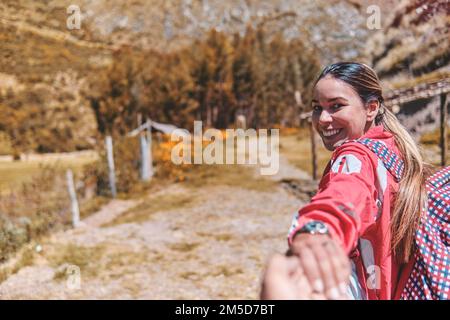 Nahaufnahme Young Woman hält einen Mann an der Hand und führt ihn durch die Natur im Freien. Konzept der Reiseliebe Stockfoto