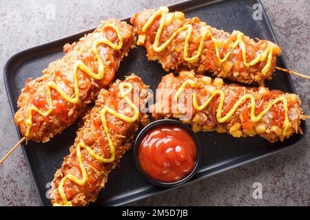 Koreanische Pommes frites Corn Dog Gamja Hotdog Nahaufnahme auf dem Teller auf dem Tisch. Horizontale Draufsicht von oben Stockfoto
