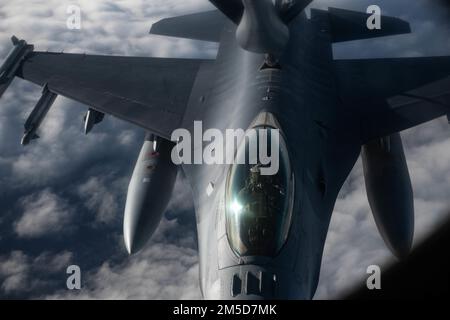 USA Air Force Captain Scott Wawrzyniak, F-16 Fighting Falcon Pilot, dem 52. Kampfflugflügel zugeteilt, erhält Treibstoff von einem KC-135 Stratotanker Flugzeug, das dem 100. Air Tanken Flügel zugeteilt wurde, 3. März 2022. USA Die Streitkräfte in Europa leben, trainieren und arbeiten mit Verbündeten und Partnern von strategischen Standorten in ganz Europa zusammen, die für eine rechtzeitige und koordinierte Reaktion in Friedenszeiten und Krisen von entscheidender Bedeutung sind. Luftbetankung ist ein wichtiger Faktor für die USA Globale Reach-Fähigkeit der Luftwaffe. Stockfoto